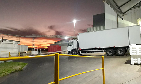 Fotografia ilustrativa de um caminhão branco, estacionado com um pôr do sol laranja no fundo. Nova operação da Sulati facilita transporte entre as indústrias da Minuano